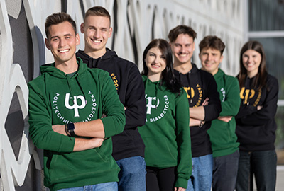 Grupa uśmiechniętych studentów PB przy budynku CNK